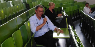 Foto von Dortmunder Oberbürgermeister Westphal, der in einem Hörsaal der TU Dortmund sitzt. 
