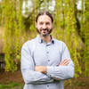 Portrait of a man in a shirt in front of a green tree