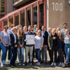 Gruppenfoto vor der Schule, einer hält eine Plakette in der Hand