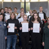 Gruppenfoto von Schüler*innen, die Urkunden in die Kamera halten.