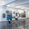 A photo of an exhibition room with white walls and many photographs.