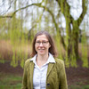 Ein Porträtfoto von einer Frau mit Brille und weißer Bluse auf dem Campus der TU Dortmund.