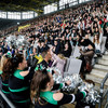 TU Dortmund's new students do a la-ola wave on a packed grandstand at the soccer stadium.