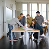 Five students stand around a table.