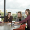 Students are sitting at a desk browsing in some documents.