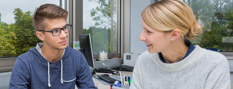 Two persons sitting at a desk