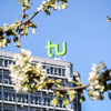 The TU building surrounded by blooming cherry blossoms.