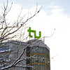 A building with TU Dortmund logo and branches covered with snow.